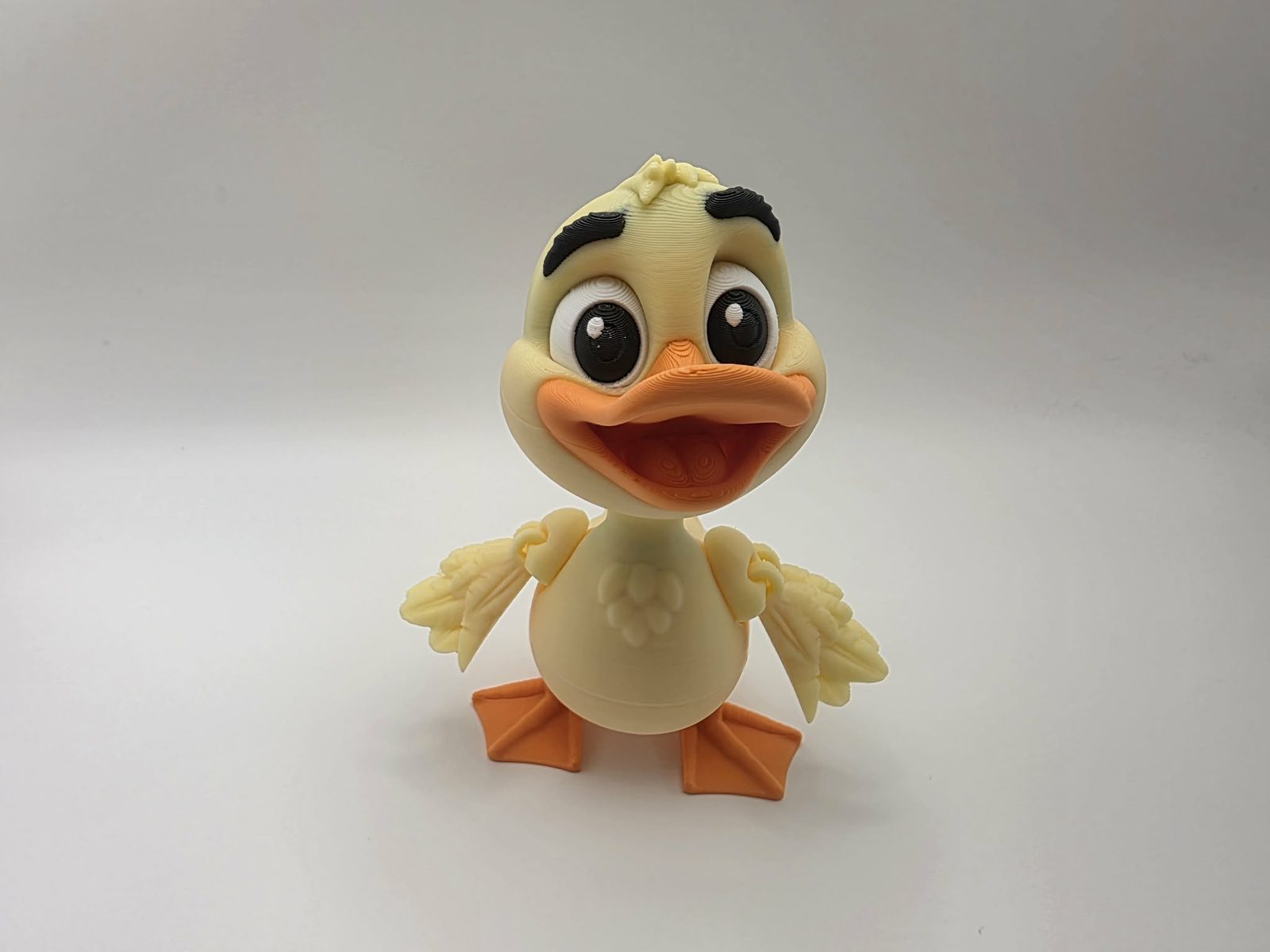 Duck - Daisy Duckling - 3.25" Outer Wing to Outer Wing x 3.5" Wide Wing to Wing x 4.25" Tall - Lemon Yellow, Sunny Orange, Black, White 3D printed item image