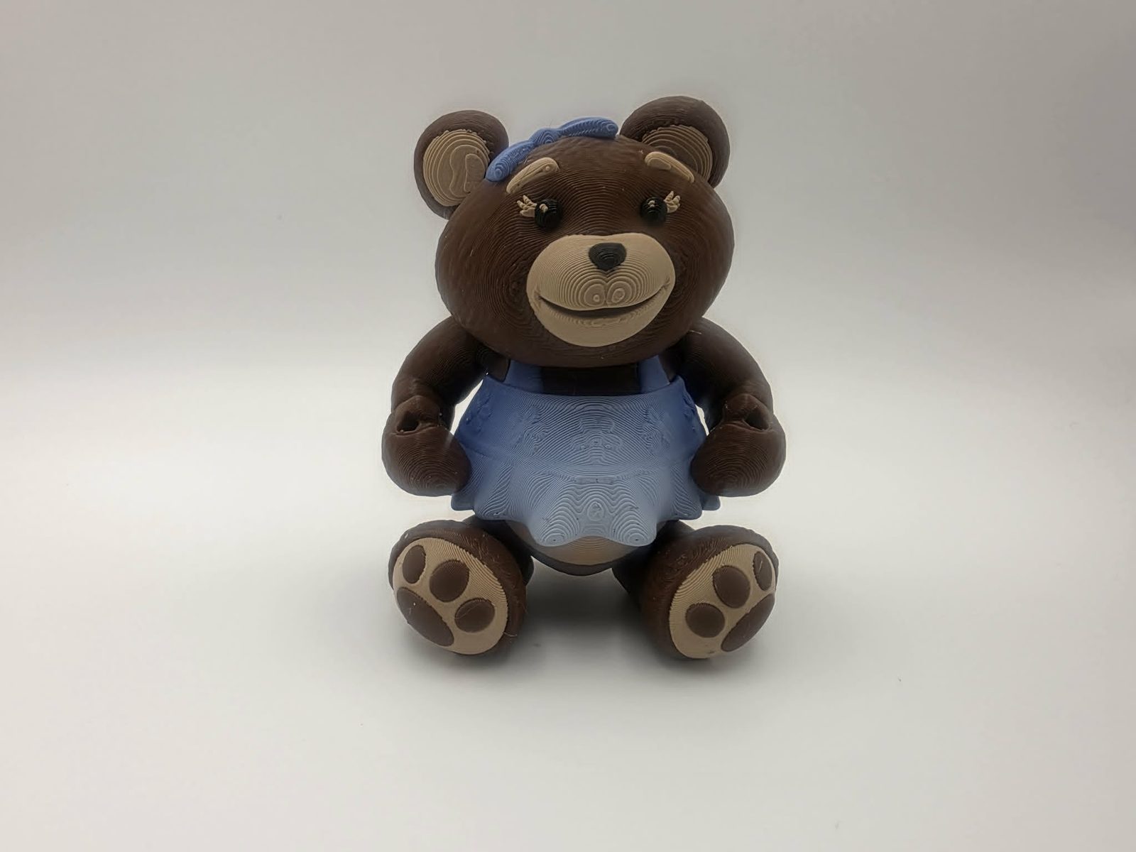 Teddy Bear - Miss Snuggleton - 3" Wide Outer Arm to Outer Arm x 1.4" Belly to Back x 4.25" Head to Feet - Chocolate, Matte Light Brown, Black, Blue and White 3D printed item image
